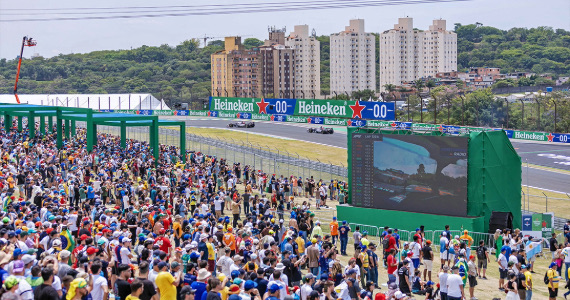 Público sobre el césped del Heineken Village Gramado de Interlagos, con la pantalla gigante y la pista al fondo