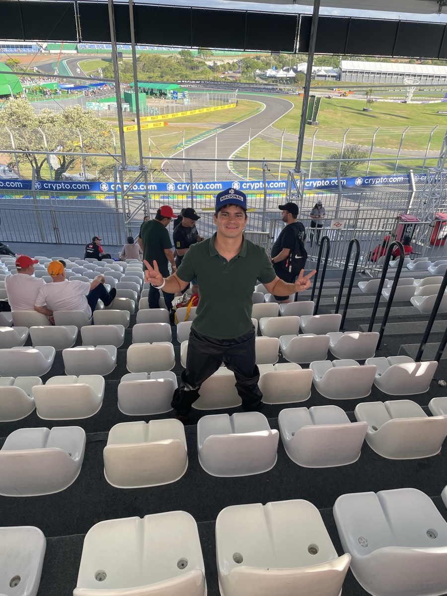 Butacas individuales blancas bajo el techo de una tribuna de Interlagos, con la pista y una curva al fondo