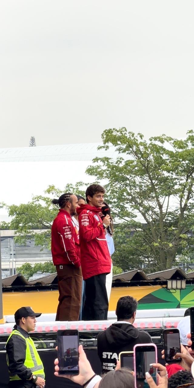 Lewis Hamilton y Charles Leclerc, con el uniforme rojo de Ferrari, sobre el escenario de la fan zone del circuito de Interlagos