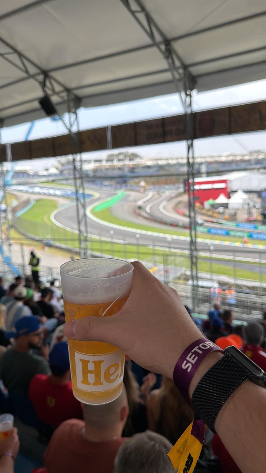 Vista de la pista desde la tribuna techada del Sector H de Interlagos, con un vaso de cerveza en primer plano