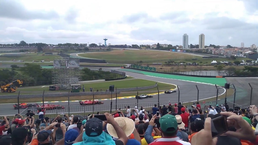 Vista desde el Sector G de Interlagos: la Reta Oposta y la salida de la Curva do Sol, con el público de pie en una tribuna sin techo