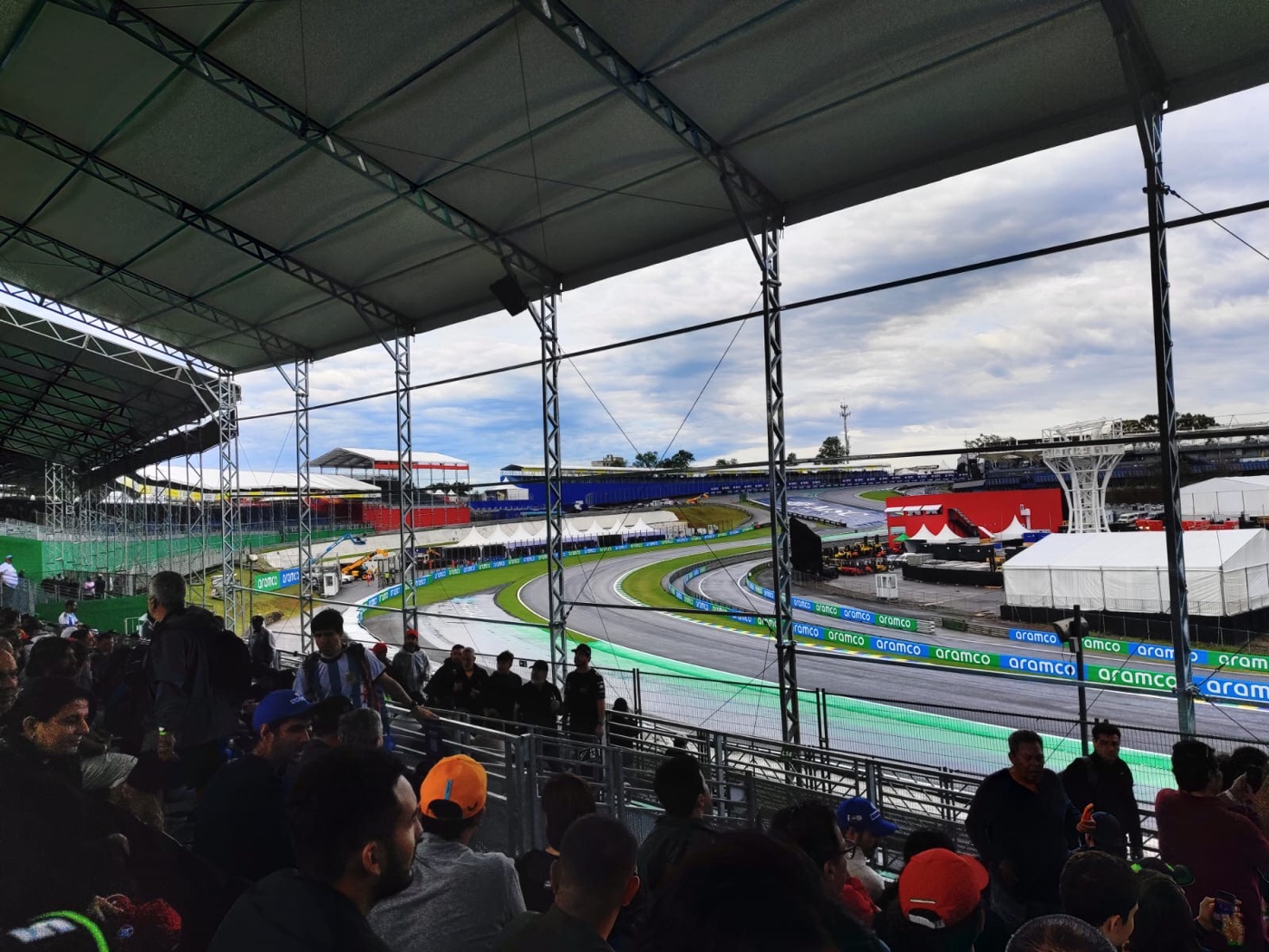 Vista desde el Sector R de Interlagos: la curva y las vallas de publicidad al borde de la pista, desde una tribuna techada y a poca altura. Foto del grupo de JUHU en el GP de 2025.